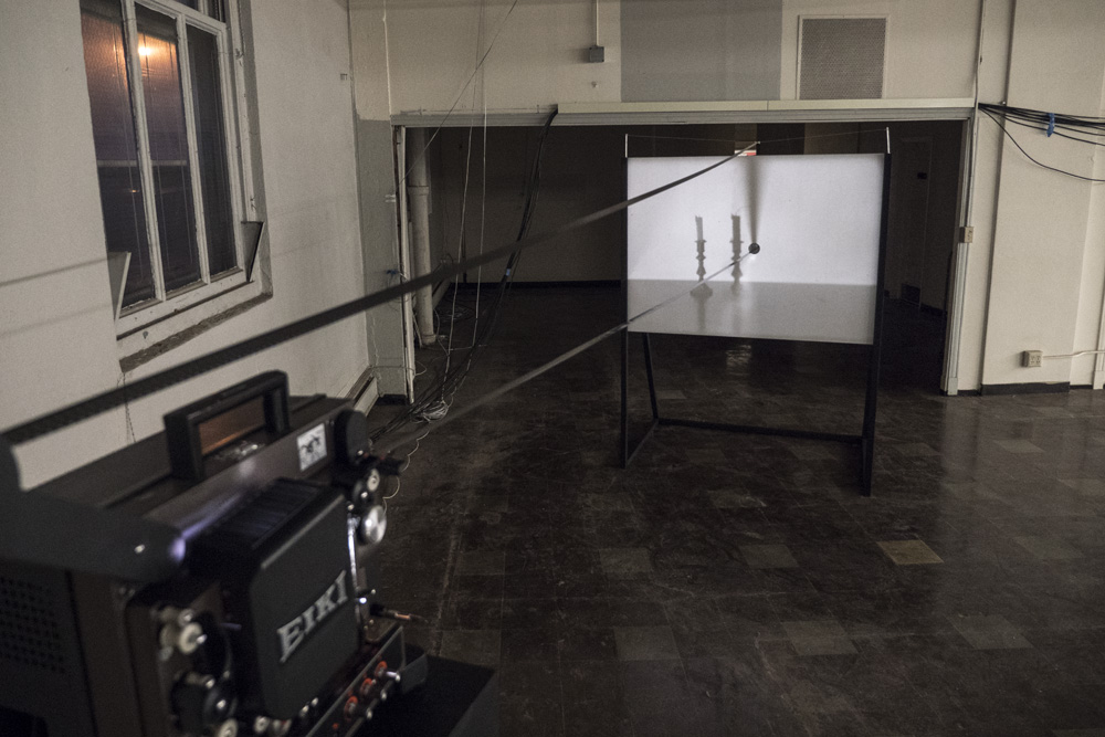 Four Shadows<br />looping 16mm film projection through punctured screen<br />2015-2016